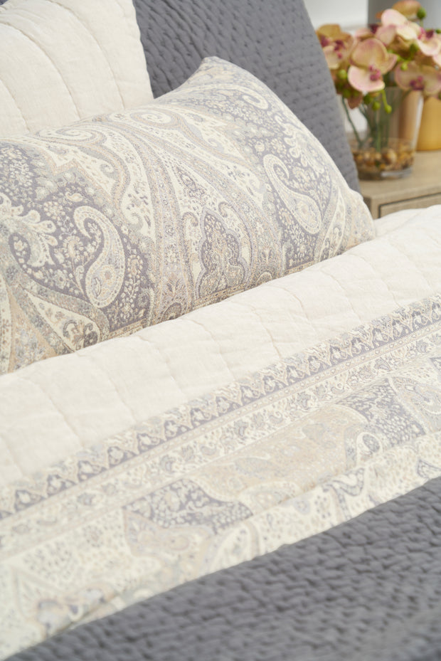 100% cotton jacquard woven coverlet with tan paisley design and matching accessories on a bed